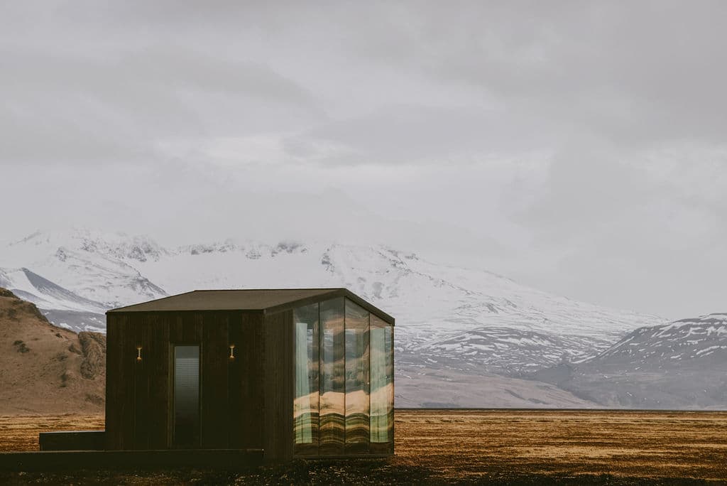 Modern cabin with large glass windows showcasing mountain views at Rafter Seljalandsfoss Georg in Hvolsvöllur, Iceland