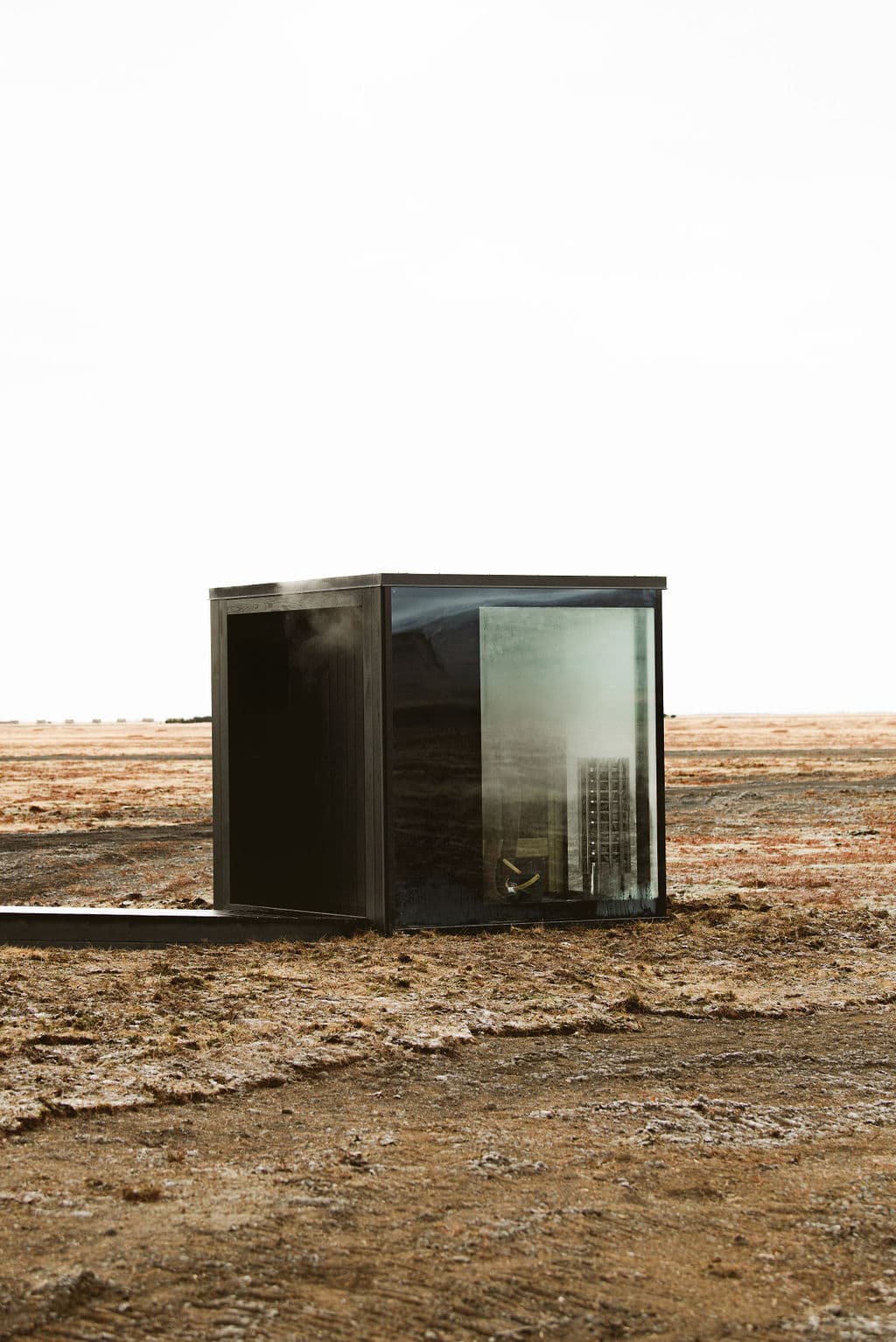 Small modern black cabin with large glass window and sauna heater at Rafter Seljalandsfoss Georg, Hvolsvöllur, Iceland