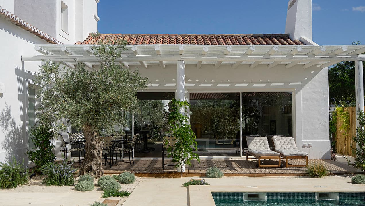 Outdoor patio with seating and lounge chairs overlooking pool at Rafter Melides Oliveiras holiday rental in Melides, Portugal