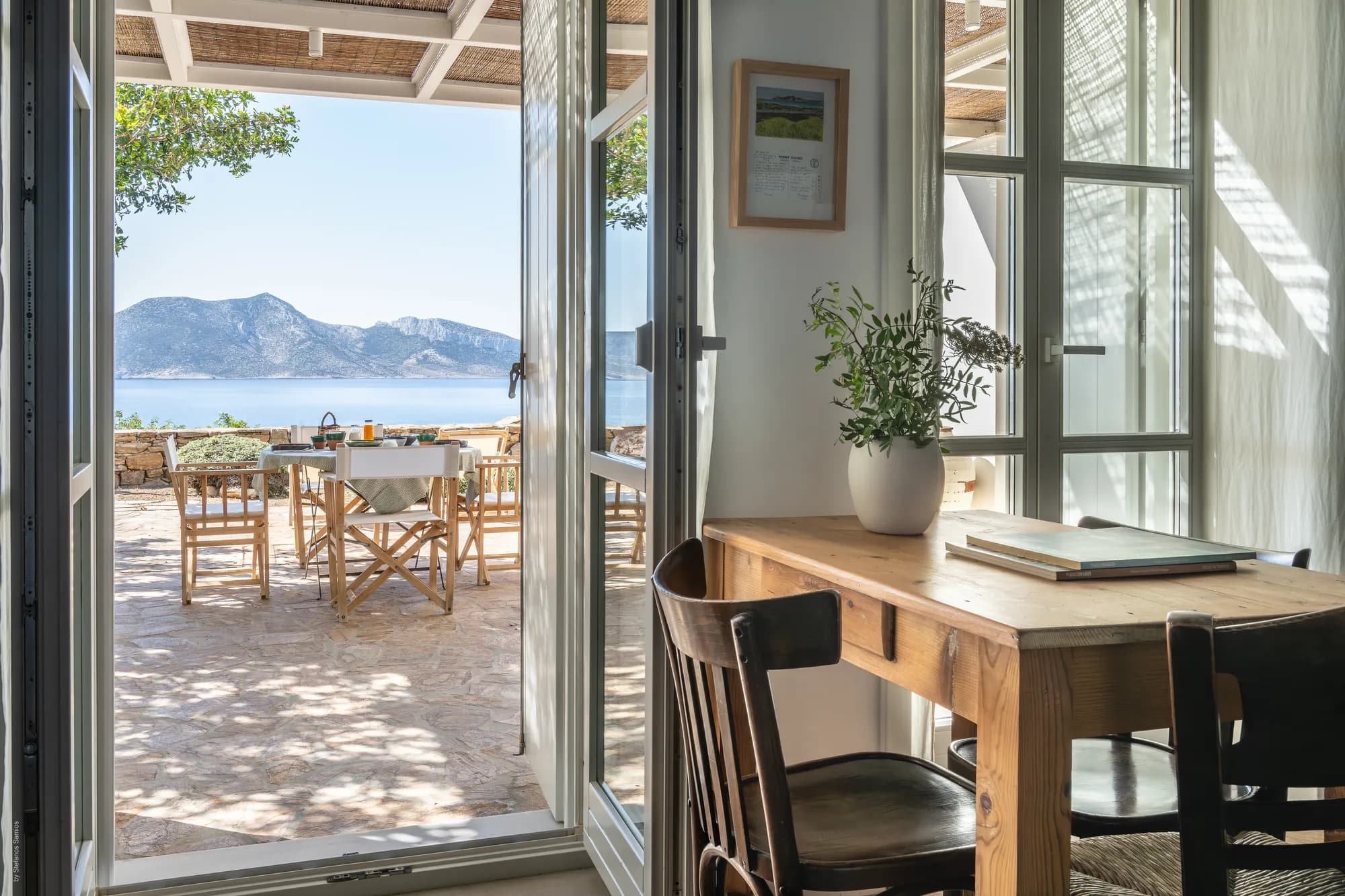 Dining area with wooden table opening to terrace and sea view at Rafter Koufonisia Galene, Koufonisia Greece