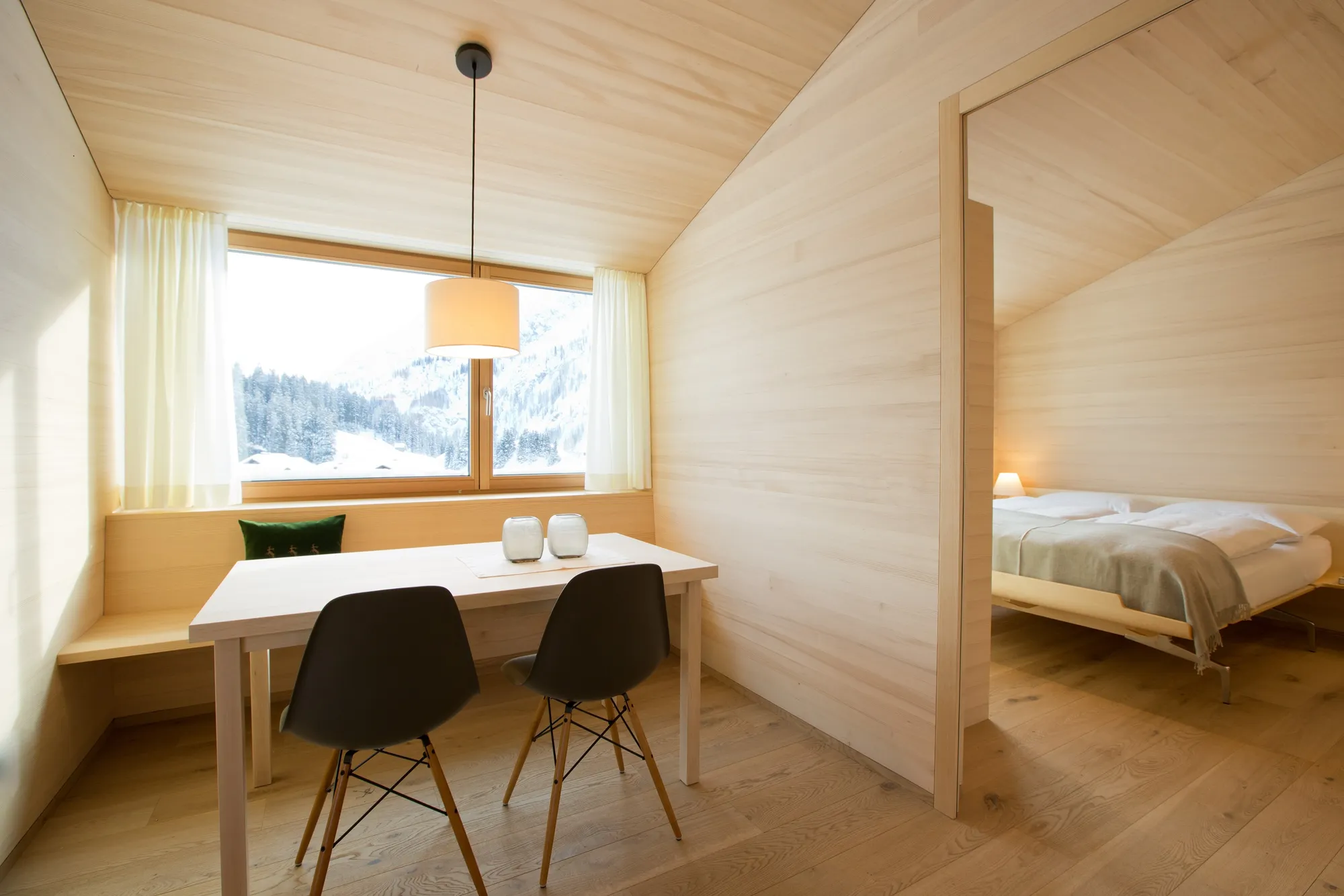 Dining area with large window and mountain view next to bedroom in Rafter Warth, Warth, Austria
