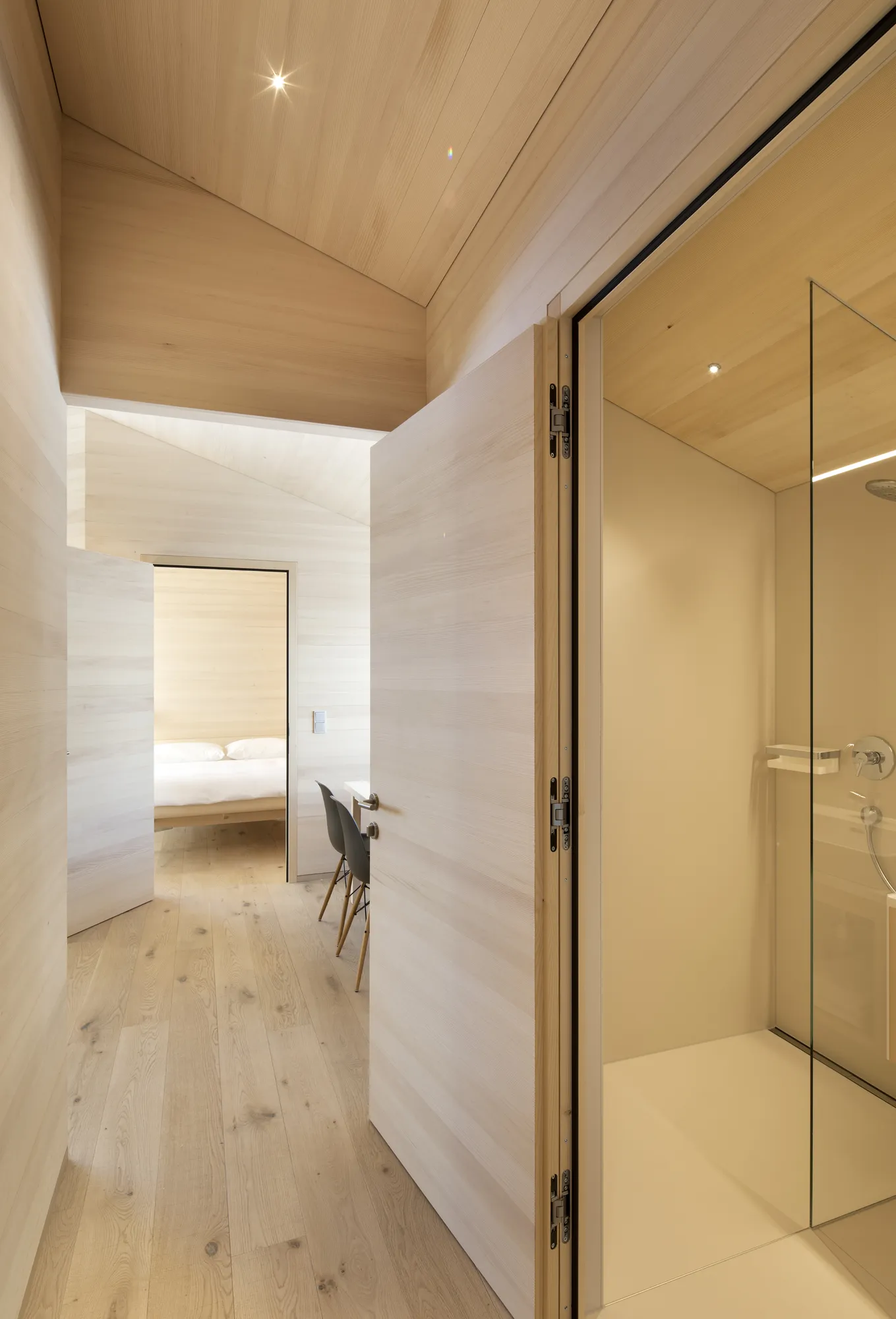 Hallway with light wood paneling, visible bedroom and shower, Rafter Warth holiday rental in Warth Austria