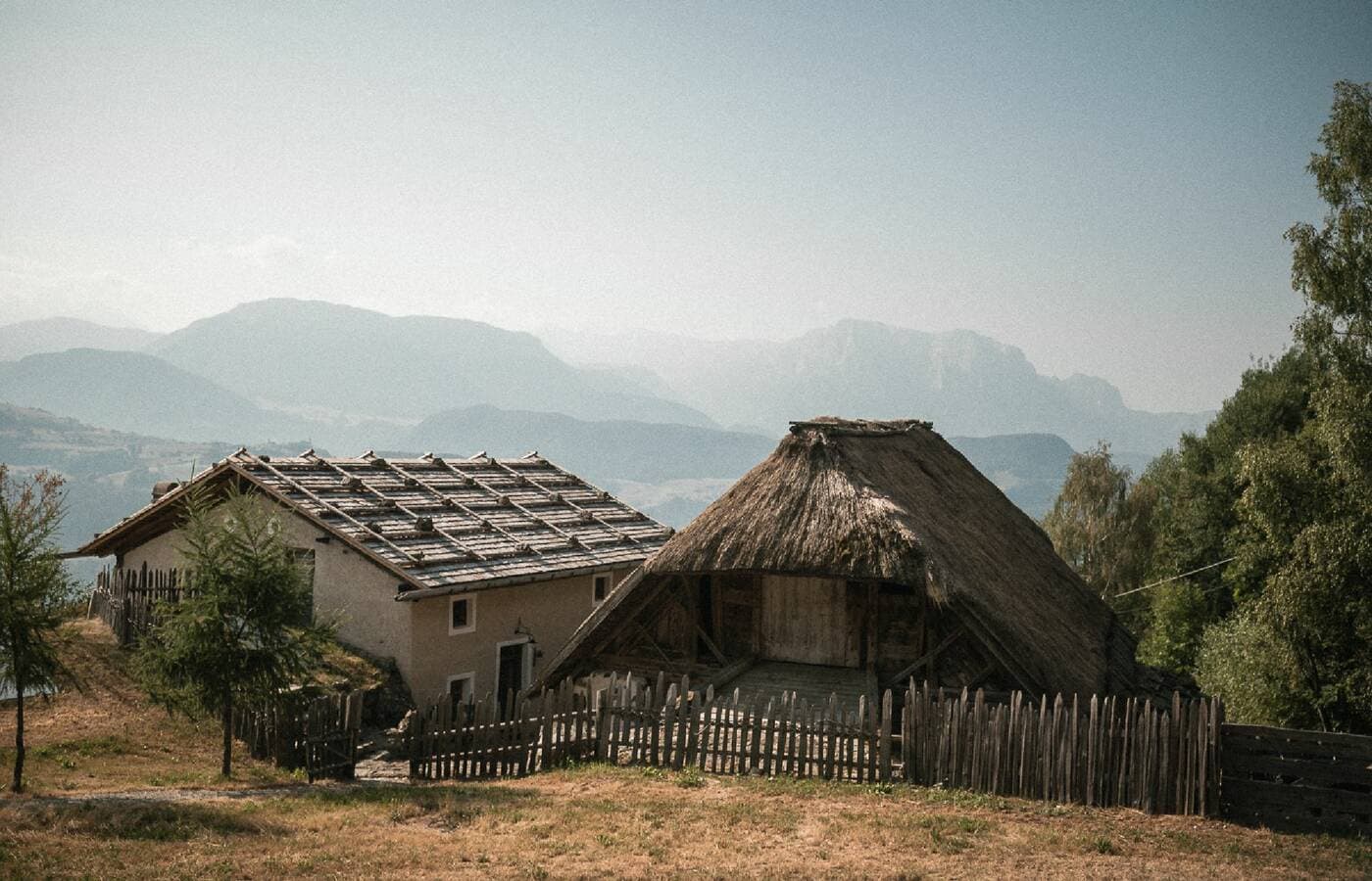 Rustic traditional buildings with thatched roof and mountain views at Rafter Villanders, Italy